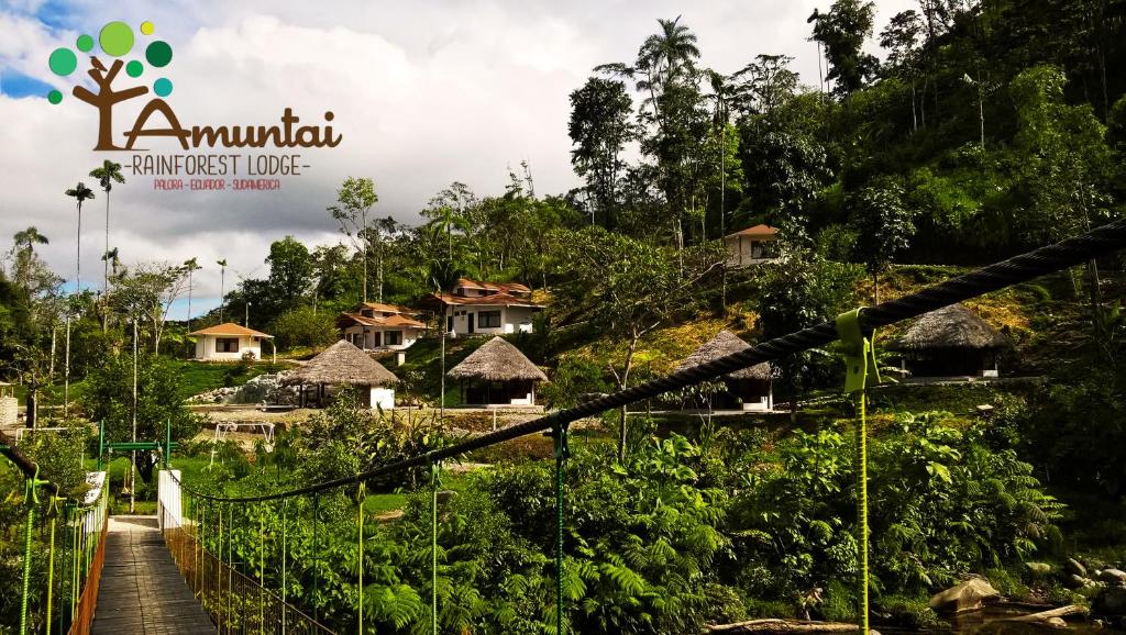 a suspension bridge over a village in the jungle at AMUNTAI RAINFOREST LODGE in Palora