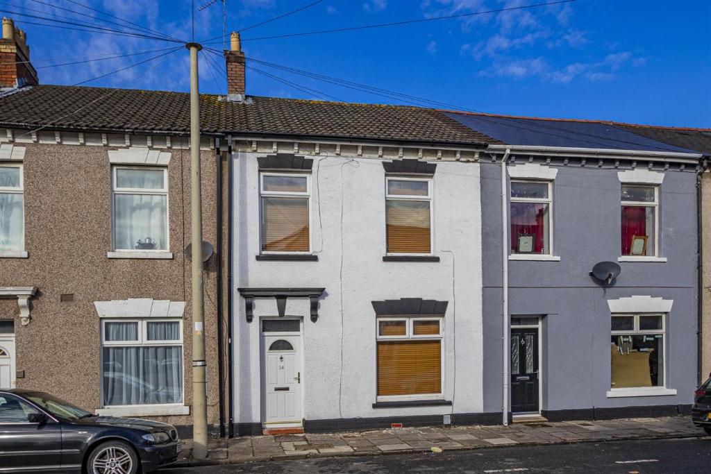 a white house with brown doors on a street at millennium stadium guest house in Cardiff