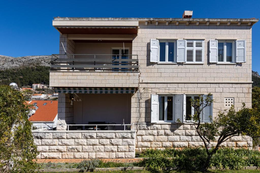a large brick house with a balcony on it at Apartments Villa Falkoni in Dubrovnik