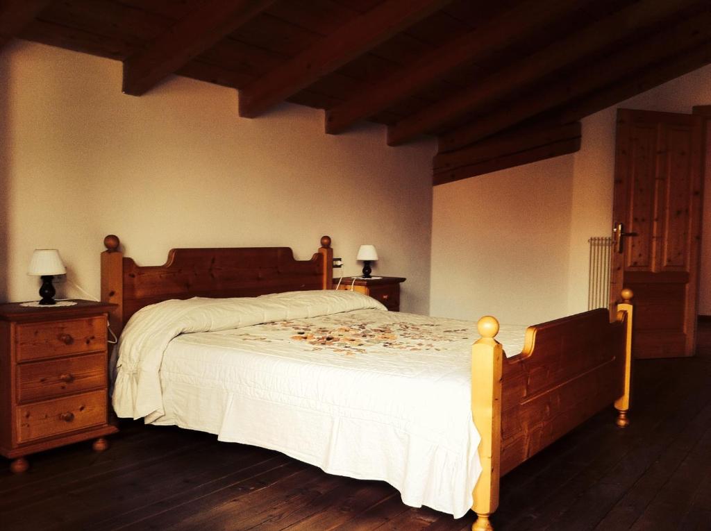 um quarto com uma cama e uma cómoda com 2 candeeiros em Casa Campetta em Comano Terme