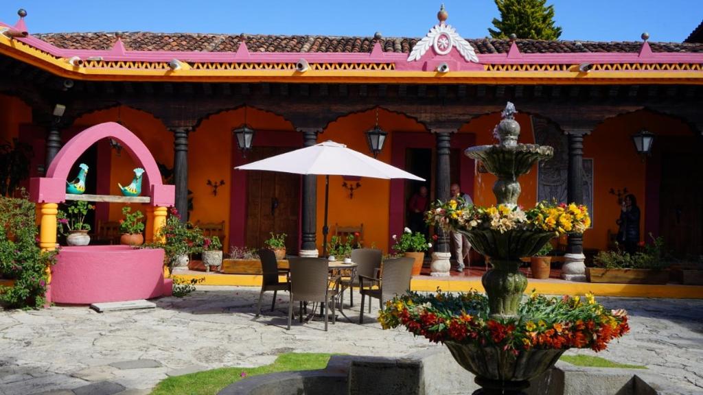 un patio con mesa y sombrilla frente a un edificio en Hotel Diego de Mazariegos, en San Cristóbal de Las Casas