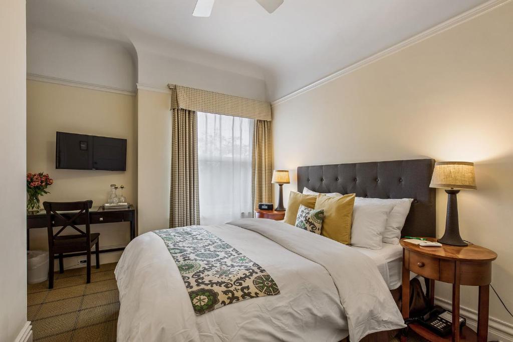 a bedroom with a bed and a desk with a chair at Parker Guest House in San Francisco
