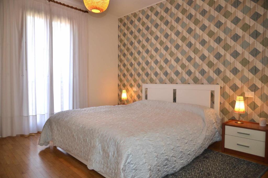 een slaapkamer met een bed en een geruite muur bij Montello Apartment Noale in Noale