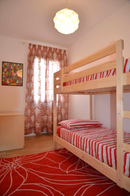 sypialnia z łóżkiem piętrowym i czerwonym dywanem w obiekcie Montello Apartment Noale w mieście Noale