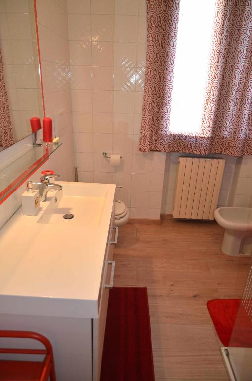 łazienka z umywalką, toaletą i oknem w obiekcie Montello Apartment Noale w mieście Noale