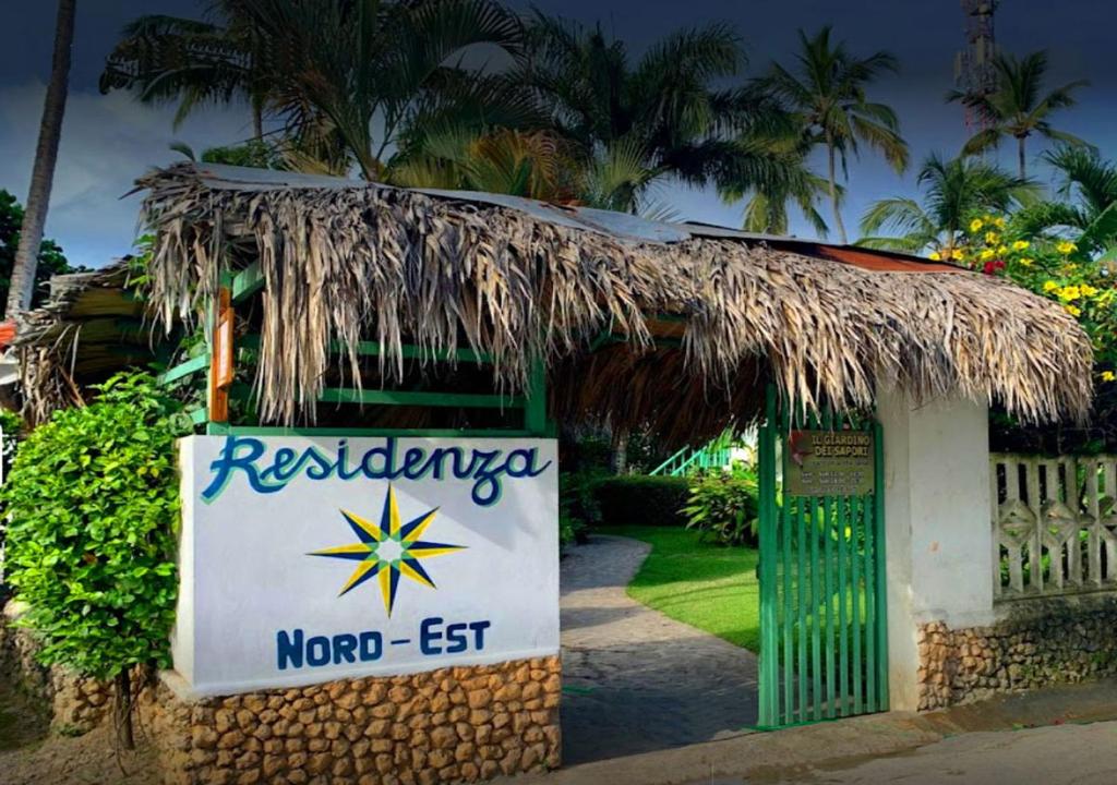 a small building with a straw roof and a sign at Residence Nord Est in Las Terrenas