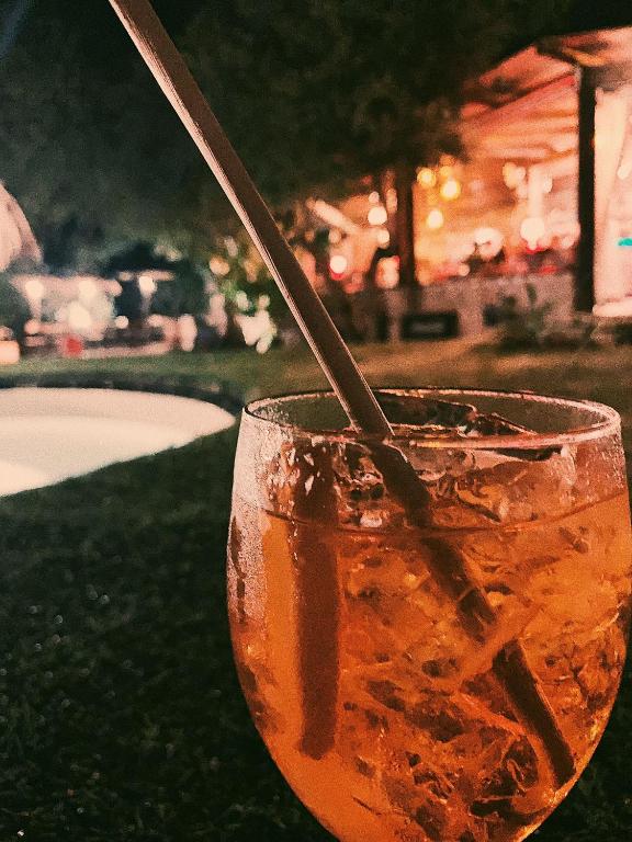 a drink in a glass sitting on the grass at L'Oasi Villaggio Albergo in Favignana
