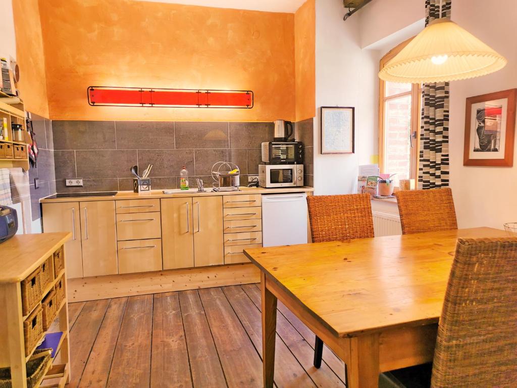 a kitchen with a wooden table and a wooden floor at Brennerei Haselberg in Wriezen