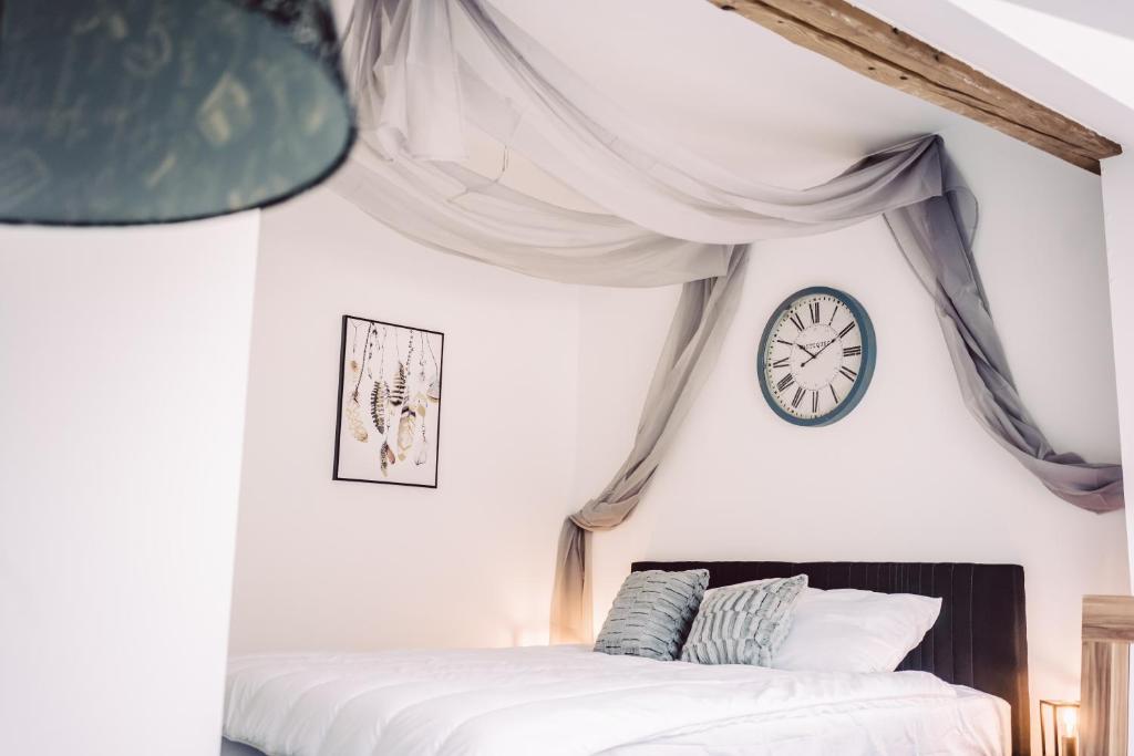 - une chambre avec un lit et une horloge murale dans l'établissement Holiday Home Alessia, à Bollendorf