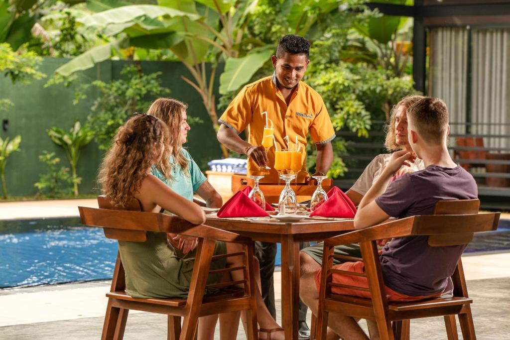 un gruppo di persone seduti intorno a un tavolo di Atha Resort a Sigiriya