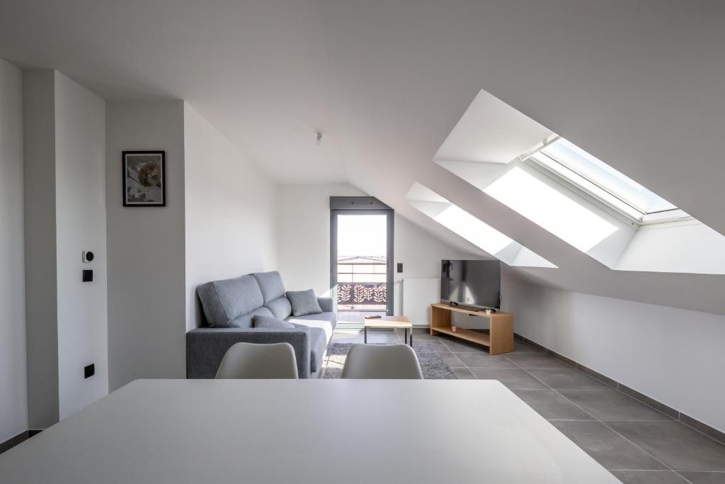 - un salon blanc avec un canapé et une fenêtre dans l'établissement Liberation, à Pontault-Combault