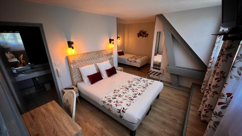 a small bedroom with a bed and a staircase at Hotel des Voyageurs in Tarnac