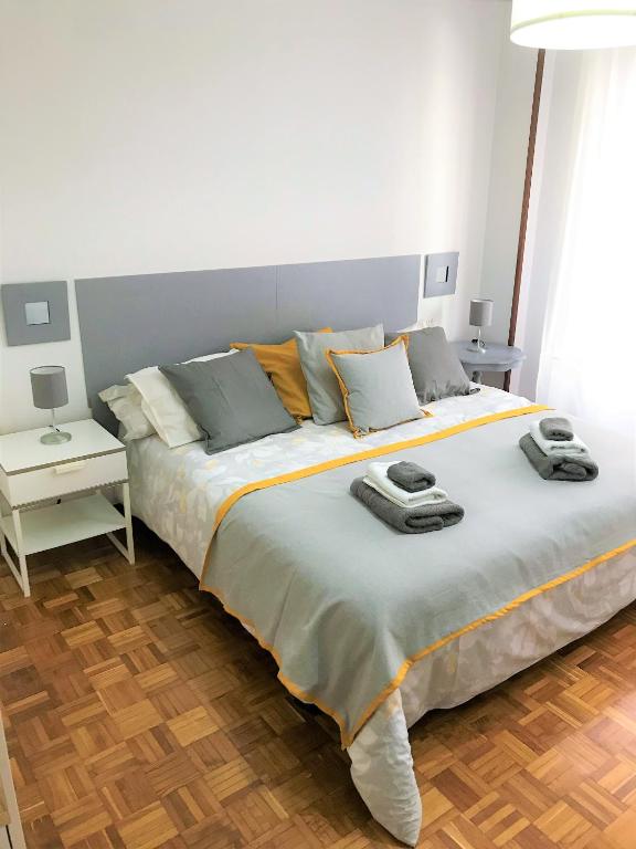 um quarto com uma cama grande com duas toalhas em Tranquilidad al lado del Centro Parking incluido em Oviedo