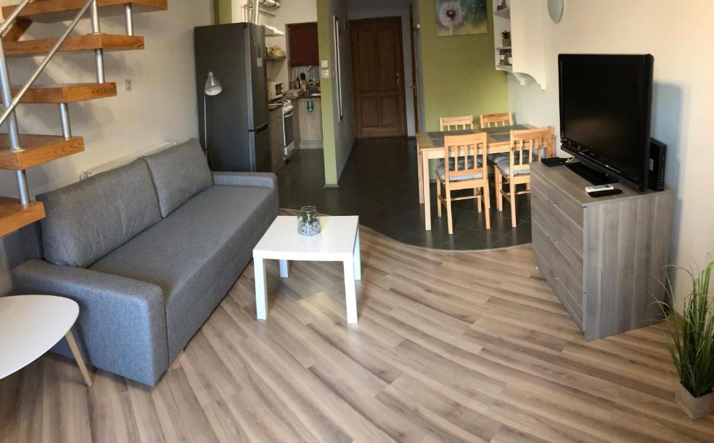 ein Wohnzimmer mit einem Sofa und einem Tisch in der Unterkunft Pitypang Apartman in Gyula