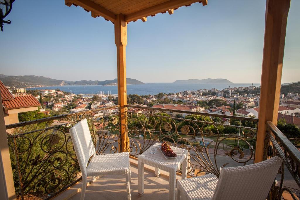 a balcony with chairs and a view of a city at Hotel Aysima in Kaş