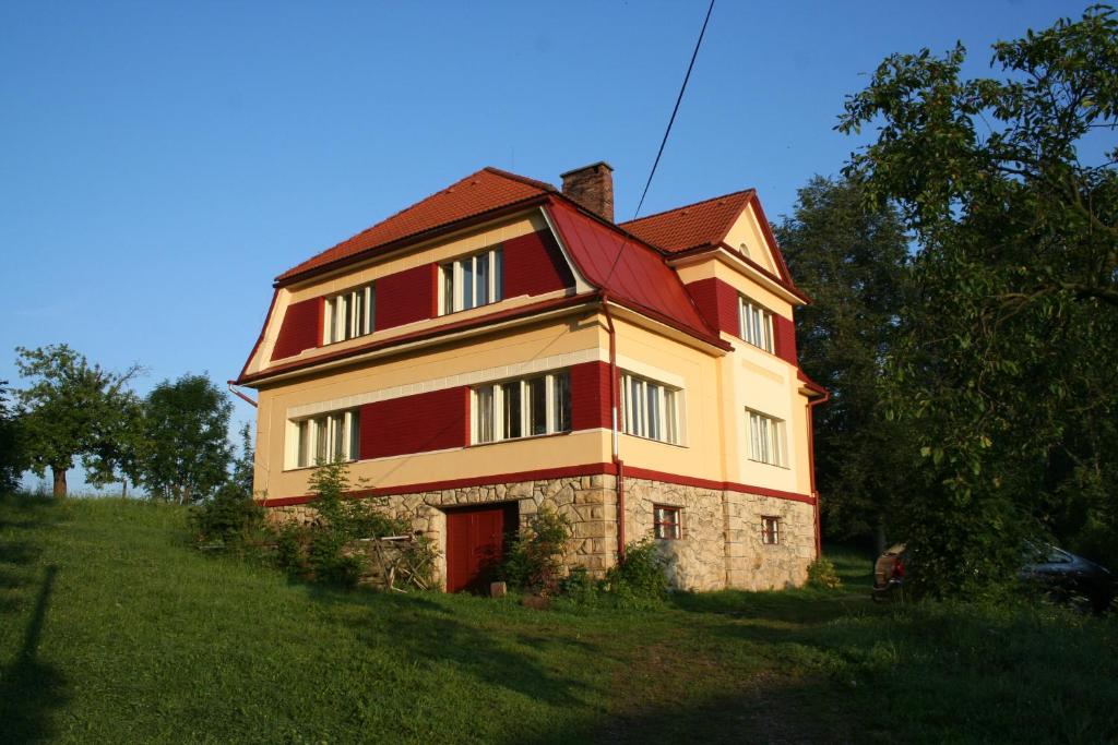 una casa grande con techo rojo en un campo en Familiehuis Fuchs, en Horní Branná