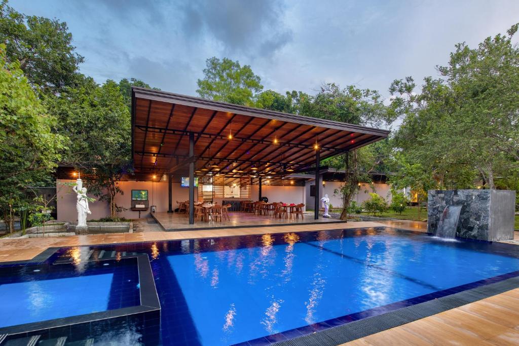 een zwembad in een achtertuin met een huis bij Atha Resort in Sigiriya