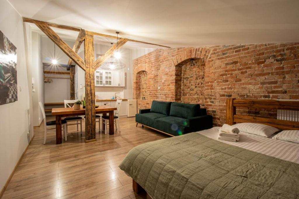 - une chambre avec un lit et un mur en briques dans l'établissement Apartament Starówka 10 (Miodova), à Toruń