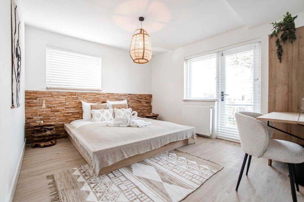 um quarto com uma cama e uma parede de tijolos em Marley’s Beachhouse - Luxury Guest Room with balcony em Zandvoort