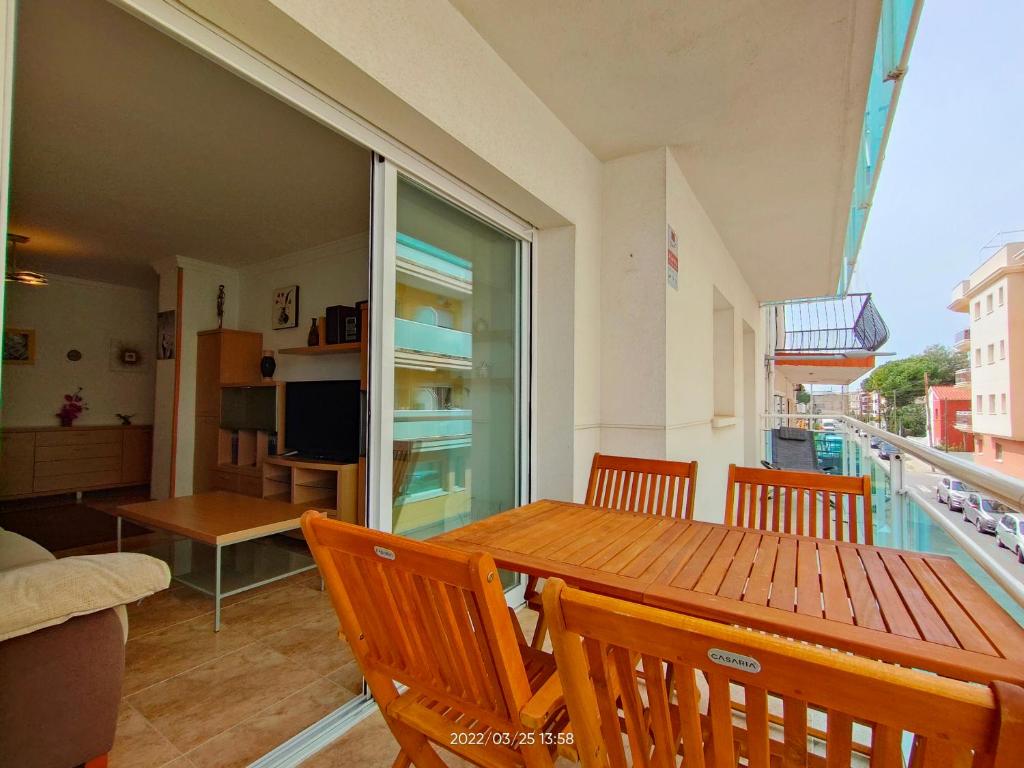 a dining room with a table and chairs and a balcony at LG Calafell Beach in Calafell