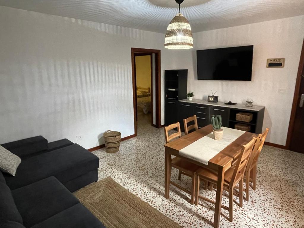 een woonkamer met een tafel en een zwarte bank bij Casa Candelaria in La Laguna