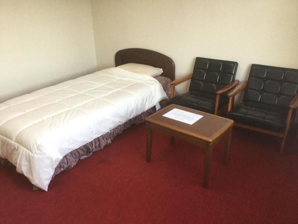 um quarto de hotel com uma cama e uma cadeira em Homestay Dream - Vacation STAY 2388 em Minami Uonuma