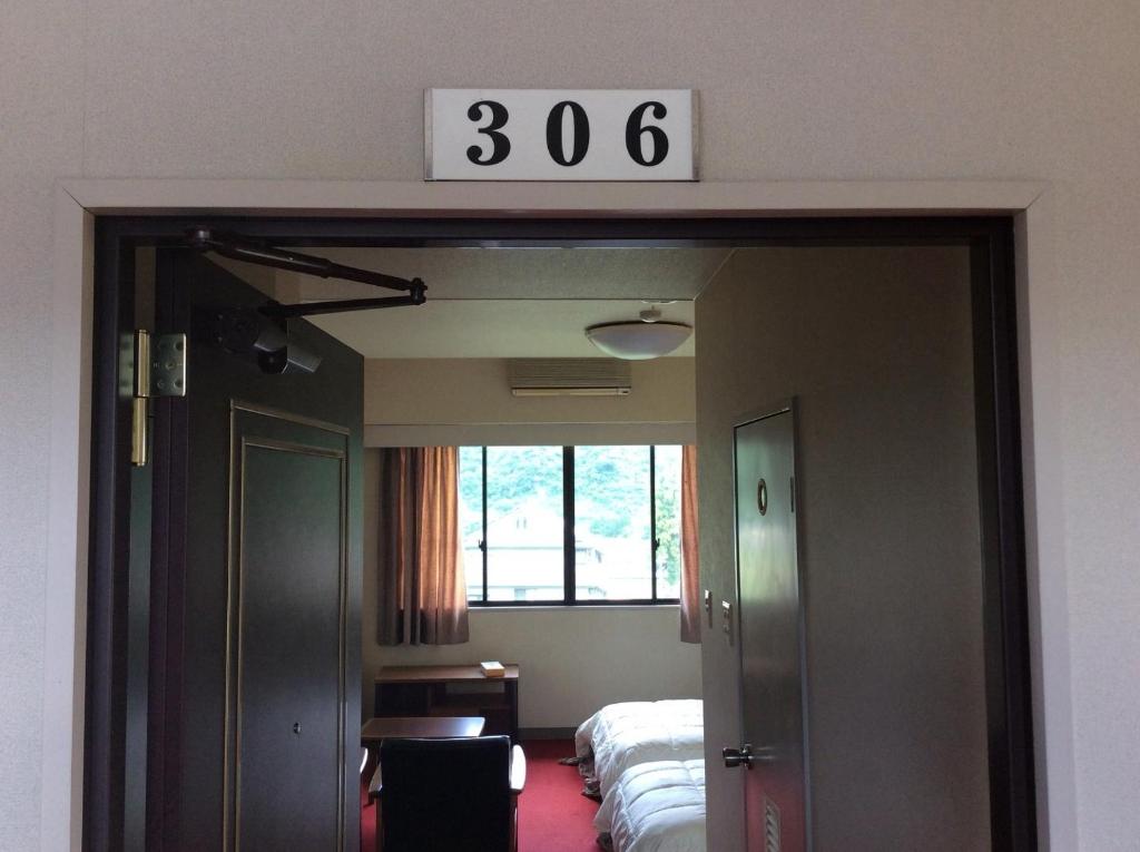 南魚沼市にあるHomestay Dream - Vacation STAY 3910のベッド1台と壁掛け時計付きの部屋