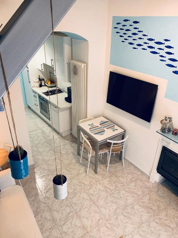 Elle comprend un petit salon avec une table et une télévision. dans l'établissement Appartamento SoloSoleMare, à Portovenere