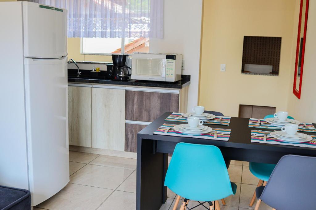 uma cozinha com uma mesa com cadeiras e um frigorífico em Apê Jabuticabeira em Pomerode