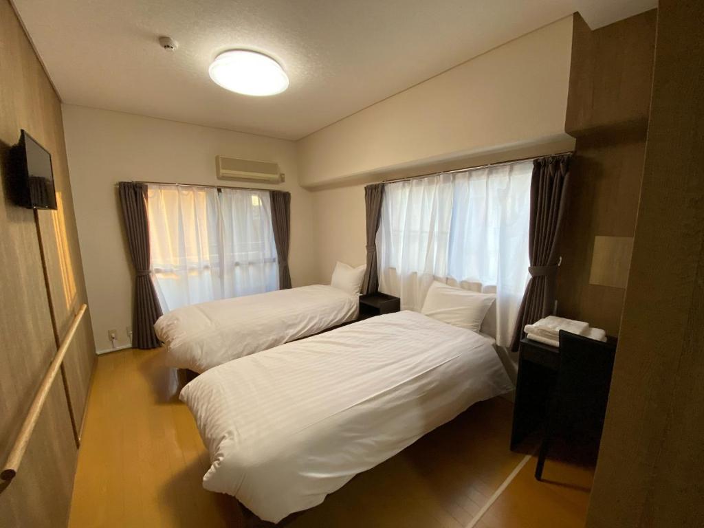 um quarto de hotel com duas camas e uma janela em Royal Heights Chuocho - Vacation STAY 12765 em Kagoshima
