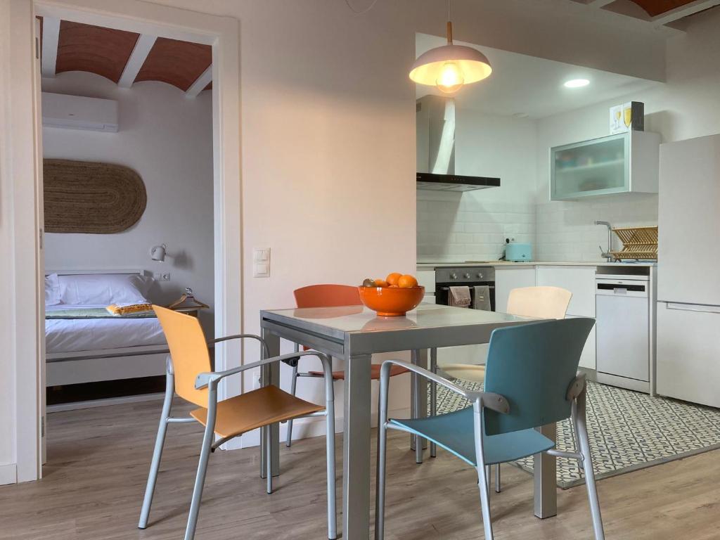 a kitchen and dining room with a table and chairs at Can Llavi in Canet de Mar