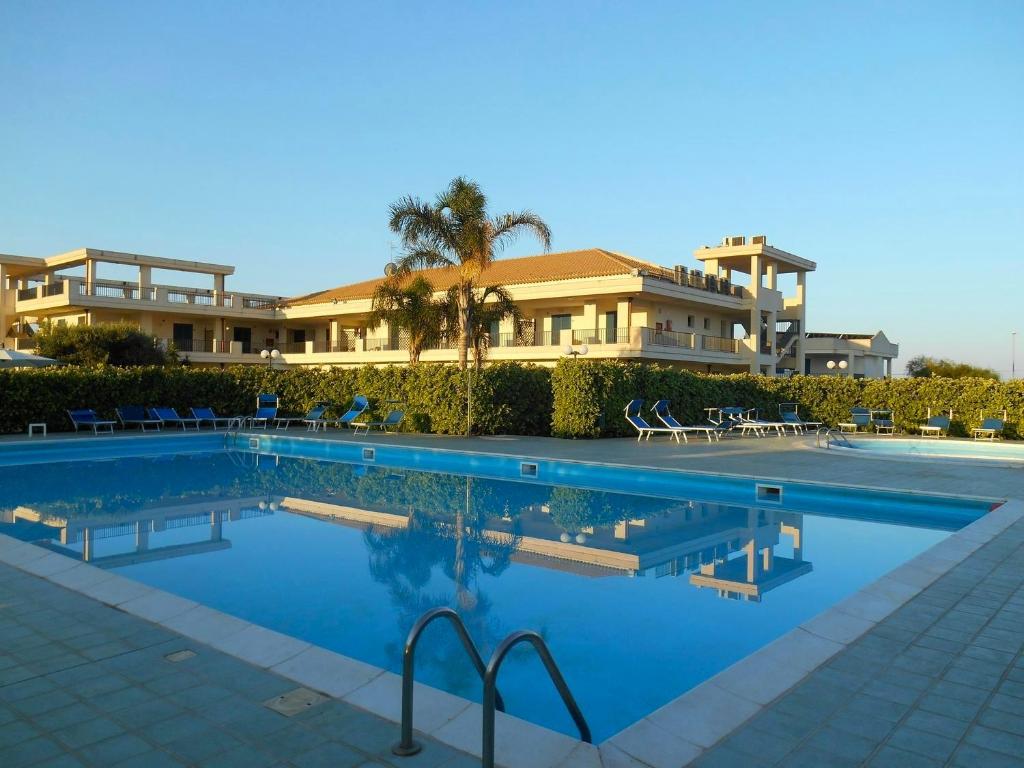 uma piscina em frente a um edifício em GH Baraka Village em Scoglitti