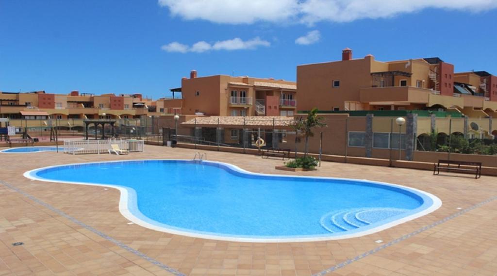 a large swimming pool in the middle of a building at Tres Islas Apartment - 70 m2 private terrace in Corralejo