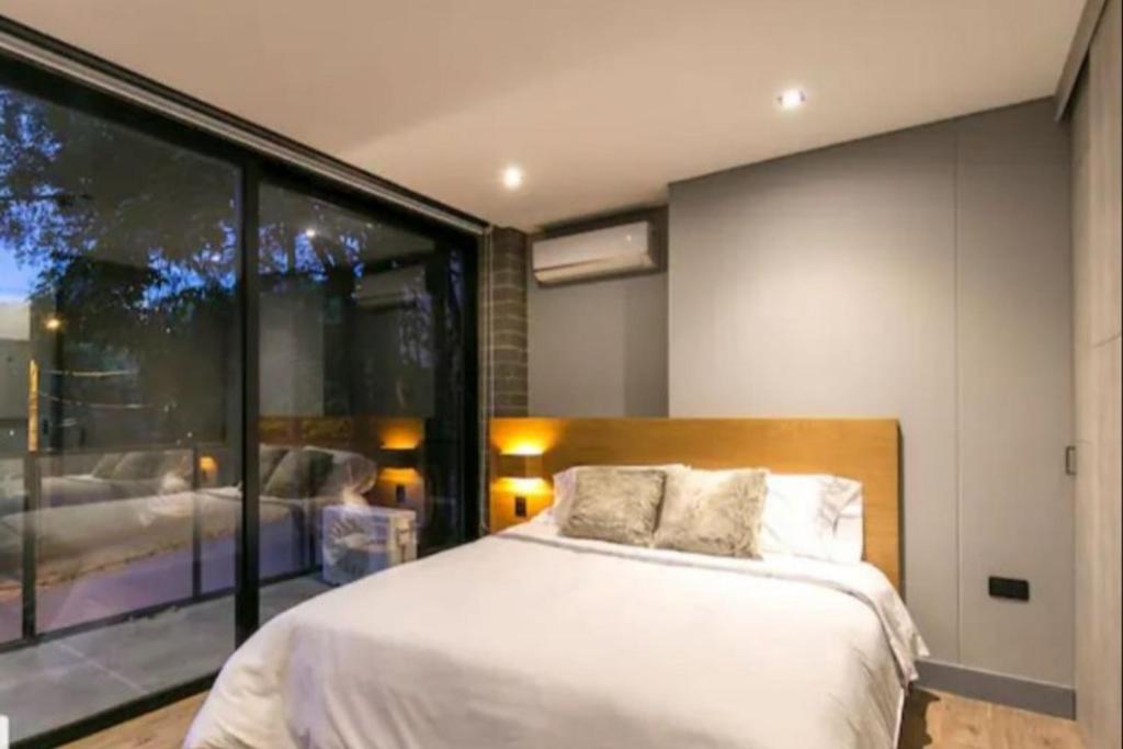 1 dormitorio con cama y ventana grande en Apartamento Familiar en Medellín Barrio el Poblado, en Medellín