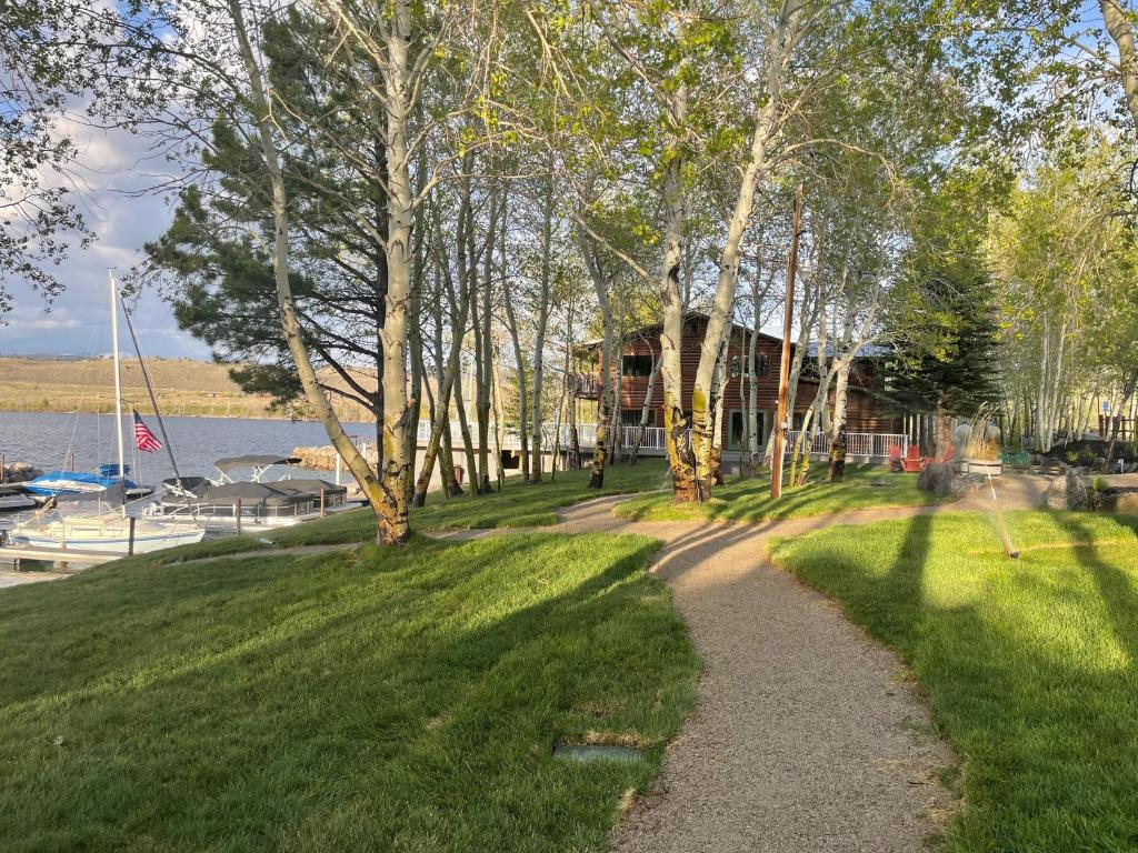 a path in a park with trees and a building at Lakeside Lodge Resort and Marina in Pinedale