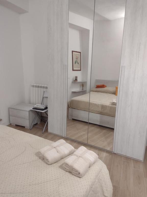 a white bedroom with a mirror and a bed at La Castellana in Spina