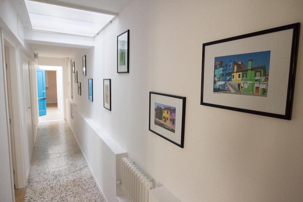 a hallway with paintings and pictures on the walls at Venice Rialto Bridge Apartment in Venice