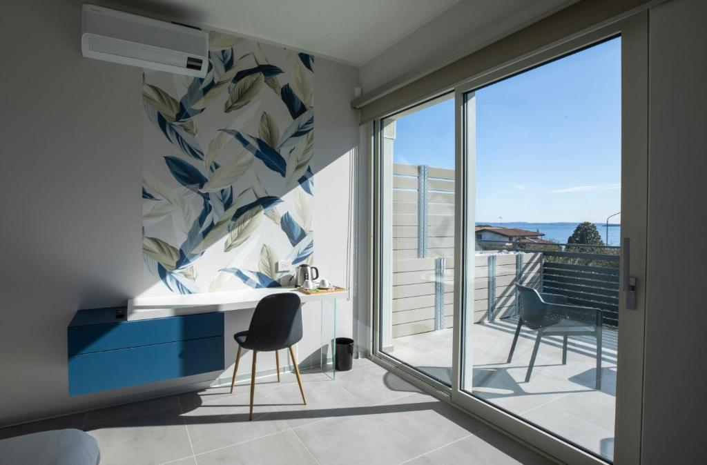 Cette chambre dispose d'un balcon avec un bureau et des chaises. dans l'établissement B&B Fior di Magnolia, à Moniga del Garda