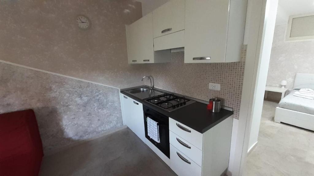 una pequeña cocina con fogones y armarios blancos en Casa vacanze Sabin, en Polignano a Mare