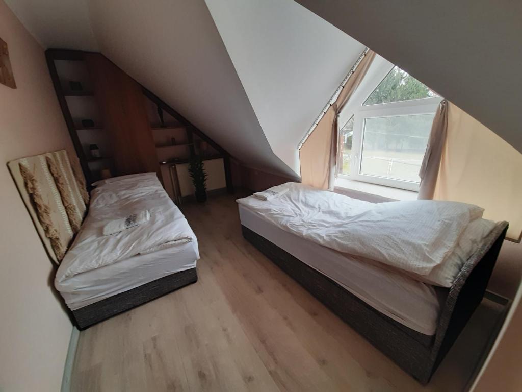 Łóżko lub łóżka w pokoju w obiekcie Egniss Apartman