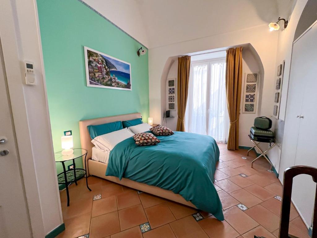 1 dormitorio con cama, mesa y ventana en Amalfi Andrea's House, en Amalfi