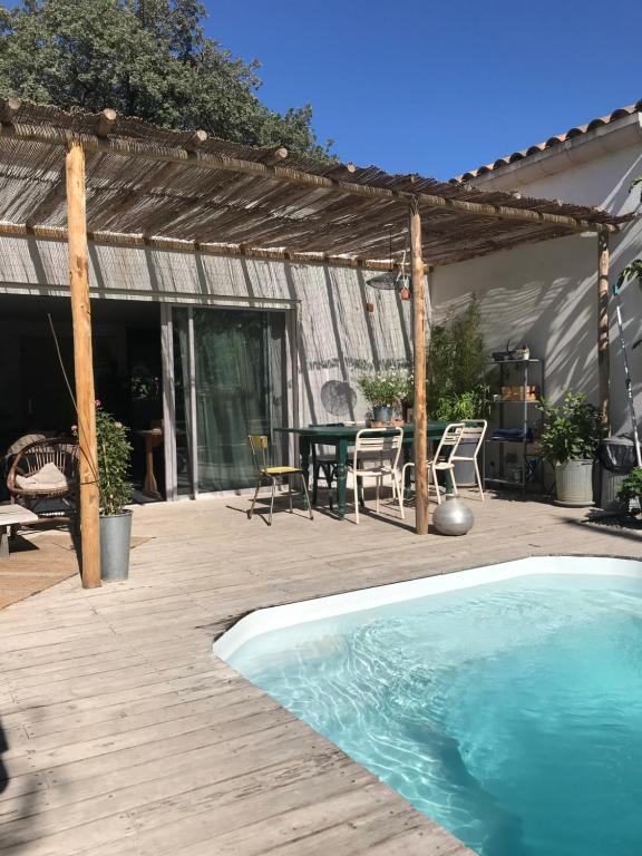 um quintal com uma piscina e um deque de madeira em Maison d hôtes LA VILLA MADELEINE em Sanary-sur-Mer