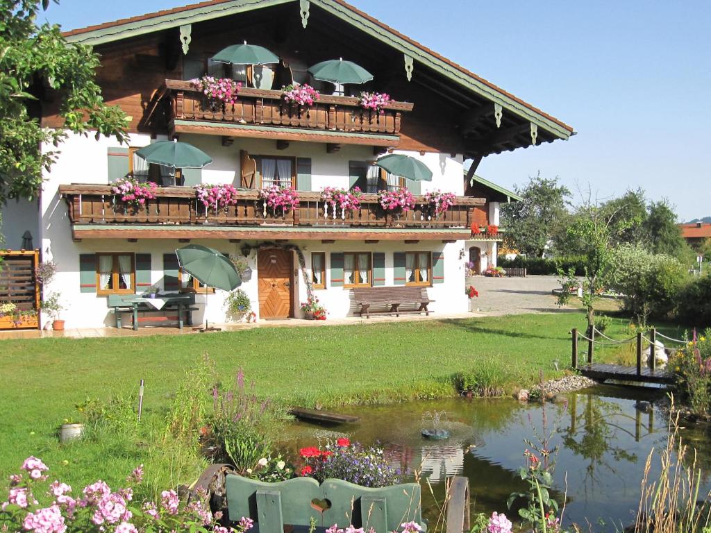 um edifício com uma varanda com um lago e flores em Hausernhof em Inzell