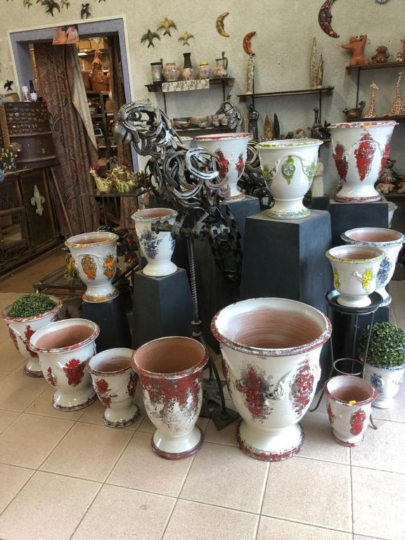 un groupe de vases assis sur un sol carrelé dans l&#39;établissement Hôtel de la Madeleine à Tornac, à Tornac