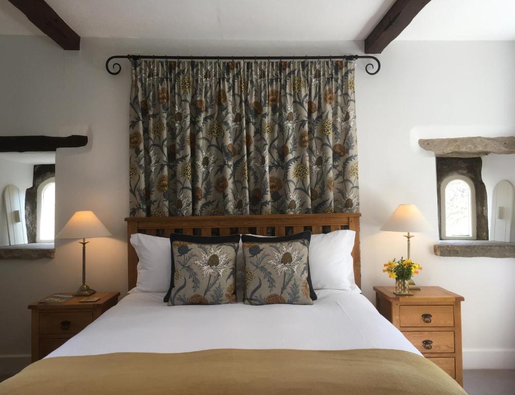 a bedroom with a large bed and a curtain at Low Raisgill B&B in Buckden