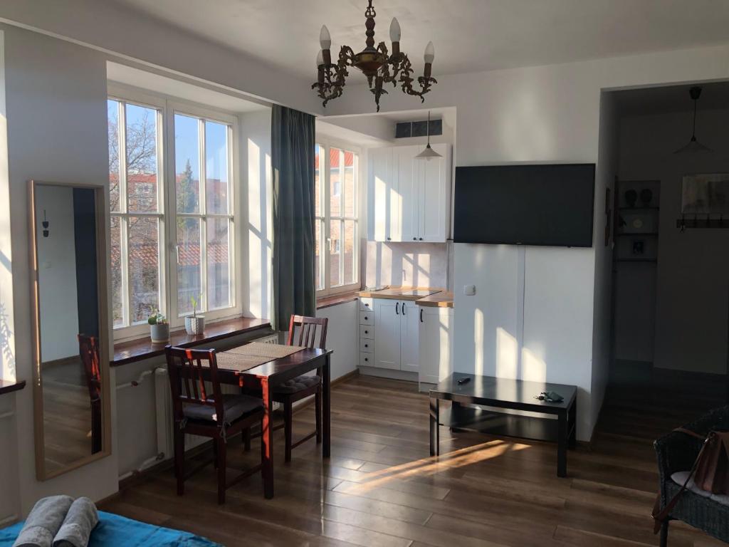 a kitchen and dining room with a table and chairs at Apartament Teatralny in Gdańsk
