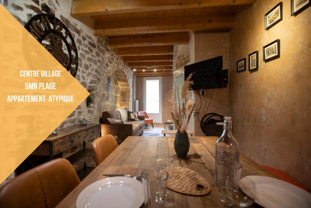 - une salle à manger avec une table en bois et un vase dans l'établissement L'Hippocampe, à Bouzigues