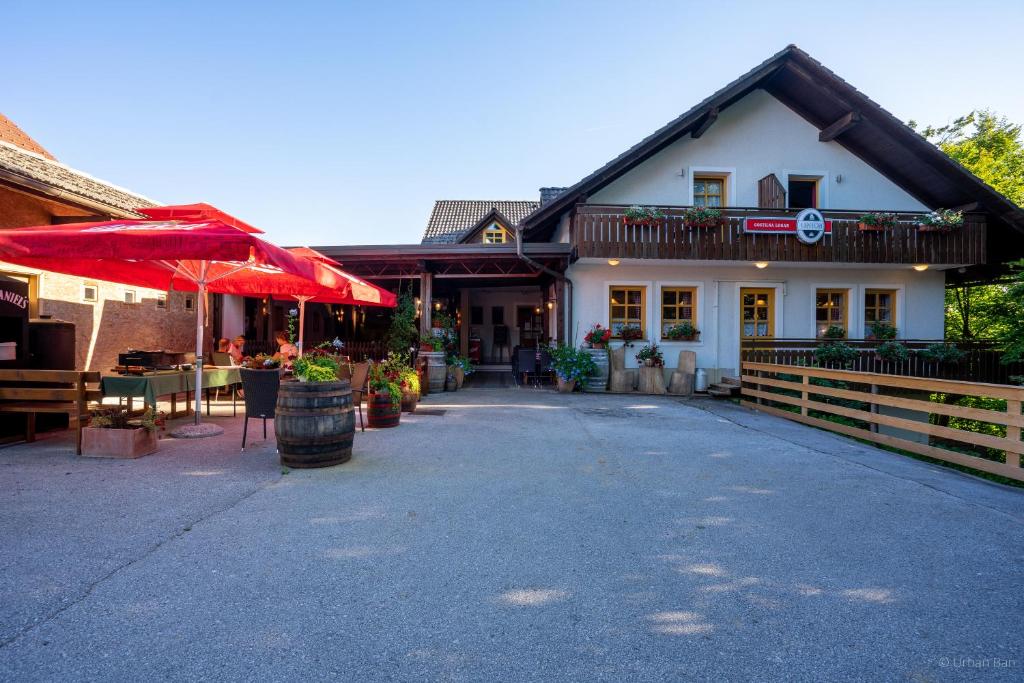 um edifício com um pátio e um restaurante com um guarda-chuva em Gostilna Logar em Hotemaže