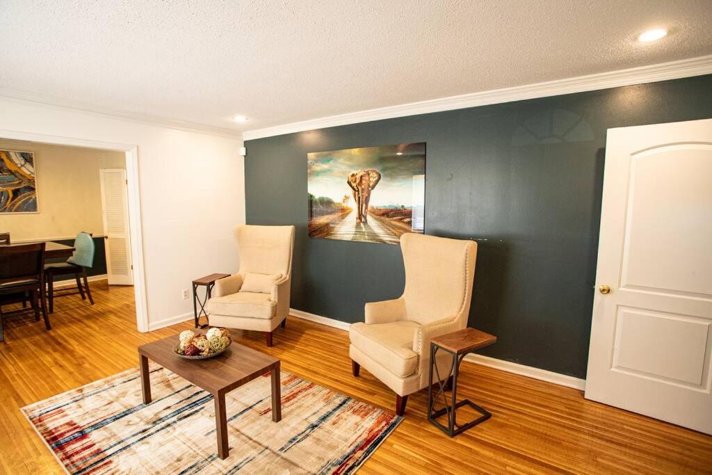 孟菲斯的住宿－The Retreat at Graceland，客厅配有两把椅子和墙上的绘画
