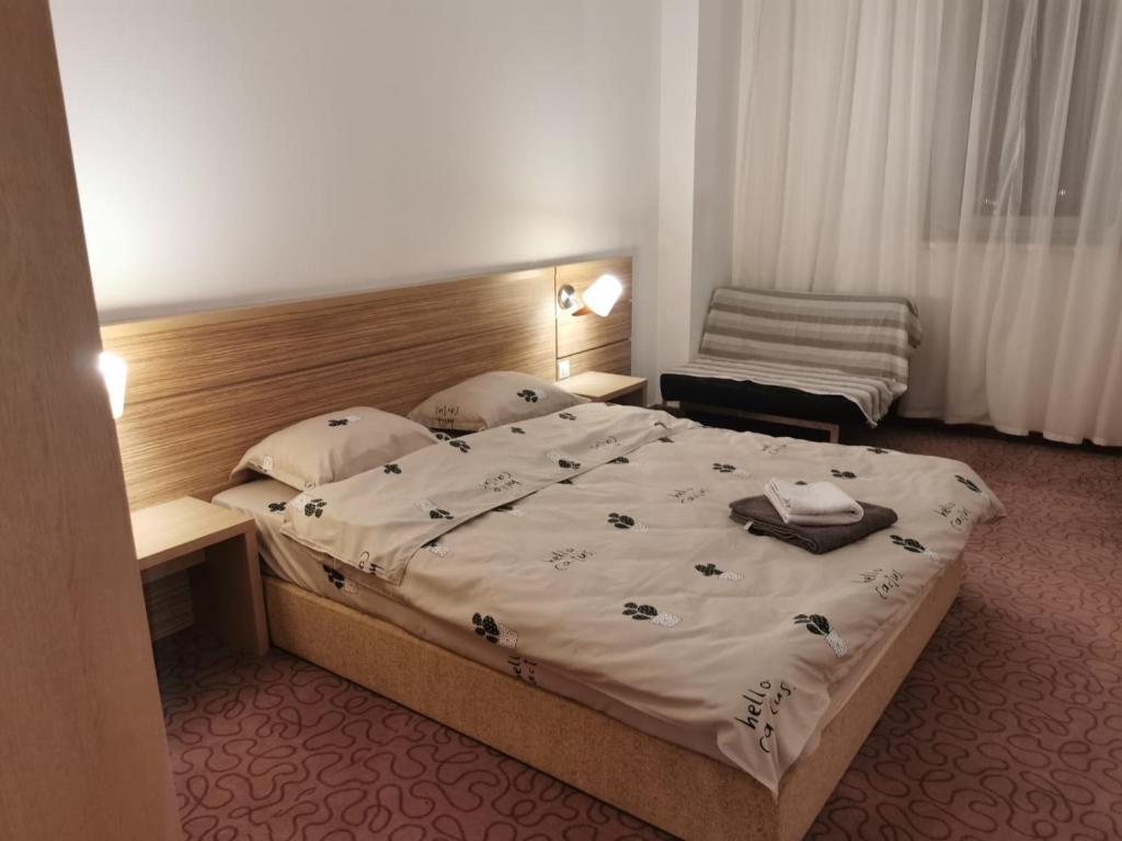 1 dormitorio con 1 cama grande y 1 silla en Rin Grand Hotel, en Bucarest